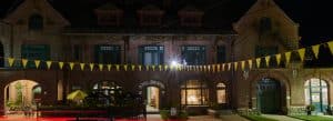 An evening photograph of the Royal Arcanum Building showing the windows of the businesses in it all lit up.
