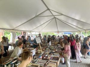 Photo of people perusing books under the tent during the Norfolk, Connecticut, Library's book sale.